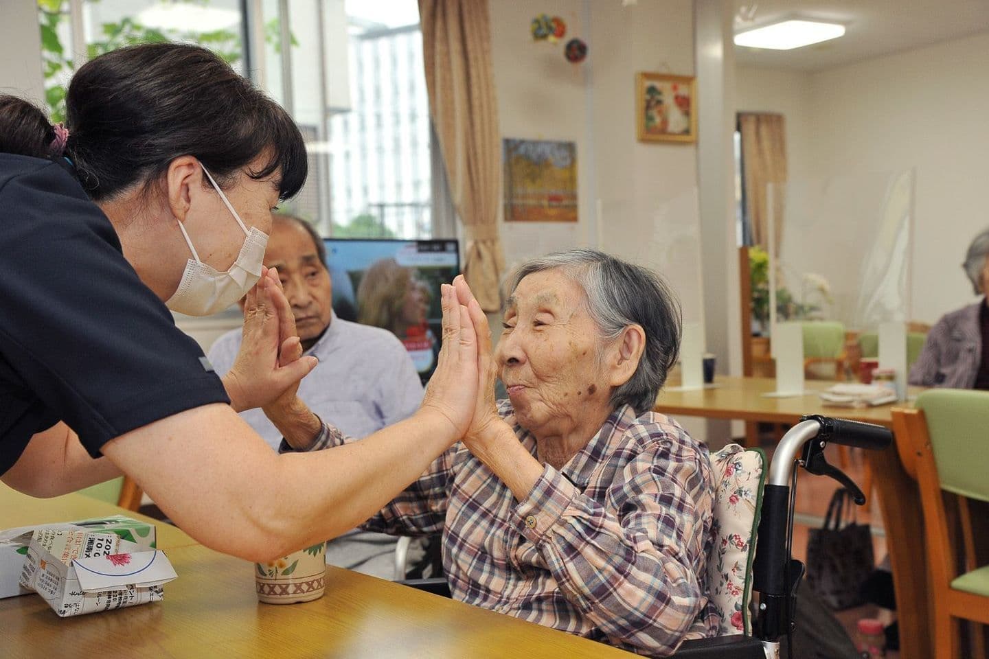 スタッフと入居者の方が手を合わせる風景